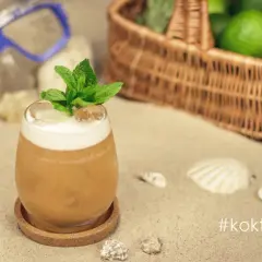 Orzeźwiający vodka sour z miętą na plaży, obok koszyka z limonkami i maski do nurkowania. Idealny na wakacje!