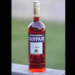 Butelka czerwonego likieru Campari z etykietą "Davide Campari Milano".