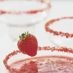 Truskawkowa margarita z ozdobnym brzegiem i świeżą truskawką.