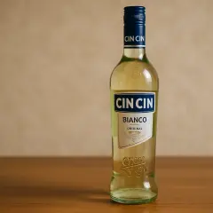 Butelka Cin Cin Bianco na drewnianym blacie. Idealna na letnie wieczory.