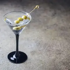 Elegancki dirty martini z trzema oliwkami na wykałaczce, gotowy do degustacji.