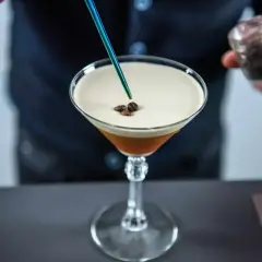 Barman dodaje ziarna kawy do drinka z pianką, przypominającego Espresso Martini. To właśnie kahlua co to za likier?
