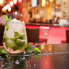 Szklanka orzeźwiającego mojito z miętą i lodem na barze.