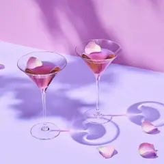 Dwa kieliszki z różowym Martini Rosso, ozdobione płatkami róż. Idealne na romantyczny wieczór. Z czym pić? Z dobrym towarzystwem!