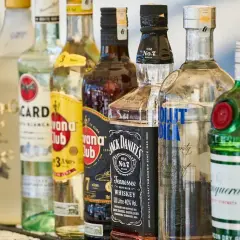 Różne rodzaje alkoholi: wódka, rum, whisky i gin. Widać butelki Bacardi, Havana Club, Jack Daniel's, Absolut i Tanqueray.