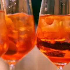 Orzeźwiający aperol bezalkoholowy z lodem w kieliszkach, idealny na letnie popołudnie.