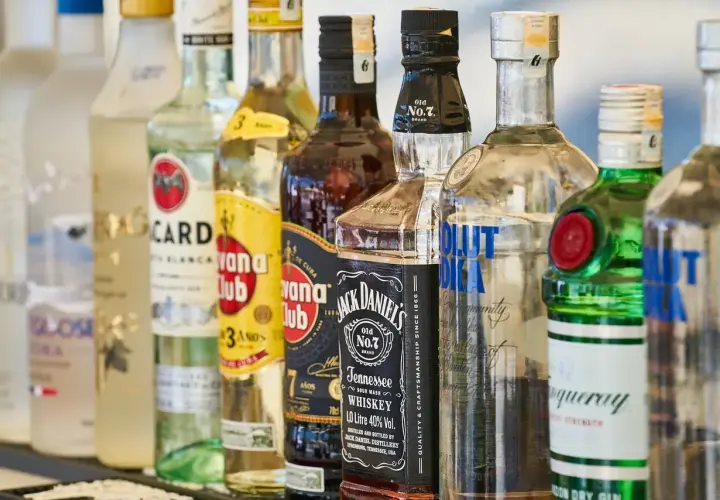 Różne rodzaje alkoholi: wódka, rum, whisky i gin. Widać butelki Bacardi, Havana Club, Jack Daniel's, Absolut i Tanqueray.
