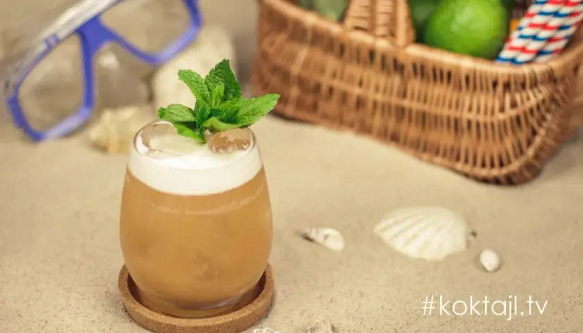 Orzeźwiający vodka sour z miętą na plaży, obok koszyka z limonkami i maski do nurkowania. Idealny na wakacje!