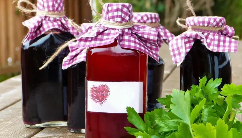 Domowe nalewki w butelkach, ozdobione kratkowanymi chusteczkami. Zastanawiasz się, ile procent ma spirytus użyty do ich produkcji?