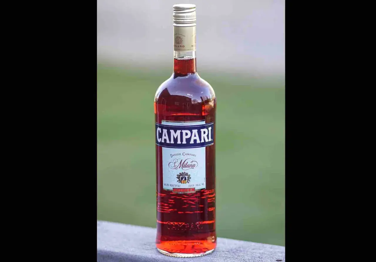Butelka czerwonego likieru Campari z etykietą "Davide Campari Milano".