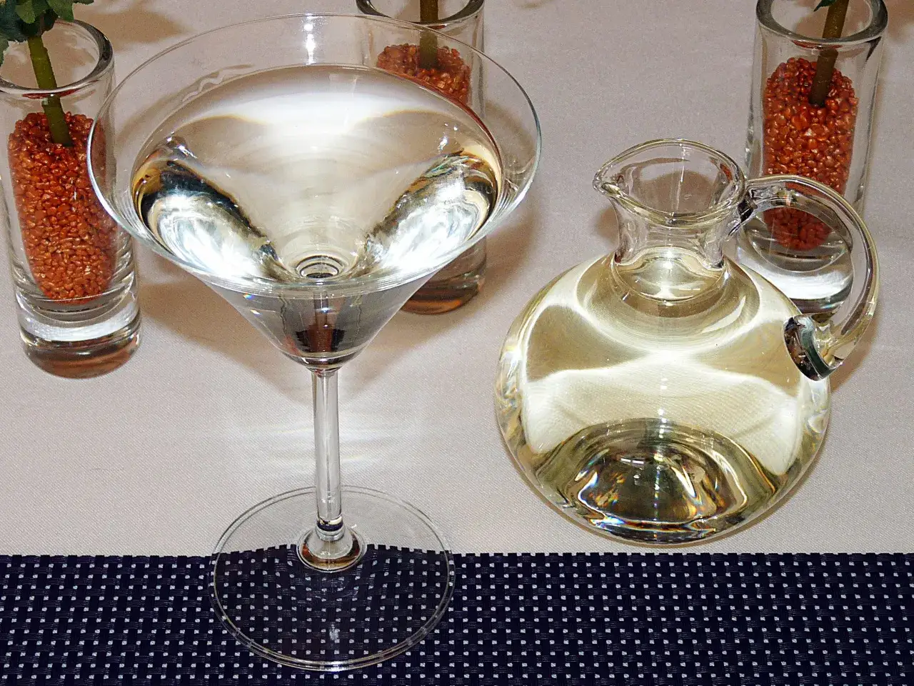 Elegancki kieliszek z drinkiem i mały dzbanuszek z płynem, jakby przygotowane dla ciociosan.