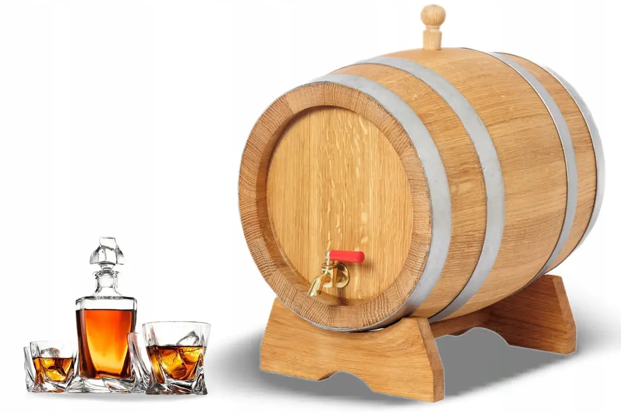 Drewniana beczka z kranikiem i karafka z whisky. Dąb nadaje trunkowi bogactwo tanin.