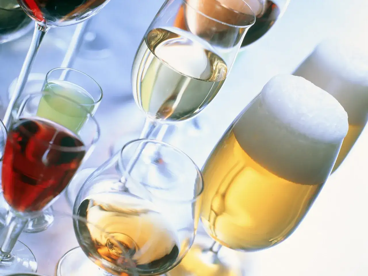 Różne napoje w kieliszkach i szklankach, w tym piwo i wino. Czy wino jest zdrowe? To pytanie pozostaje otwarte.