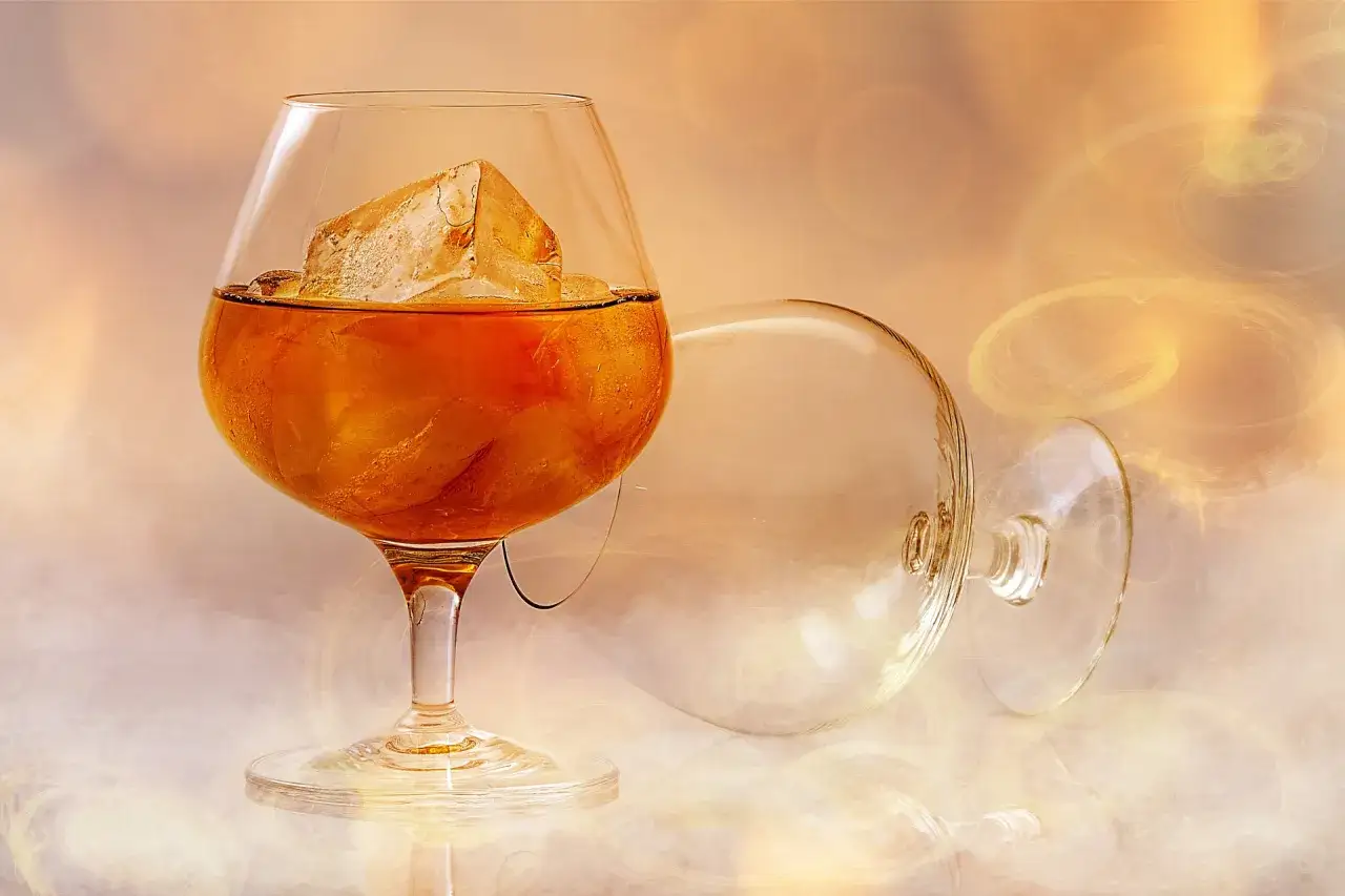 Kieliszek brandy z lodem, obok leży pusty kieliszek. Idealne do delektowania się smakiem.